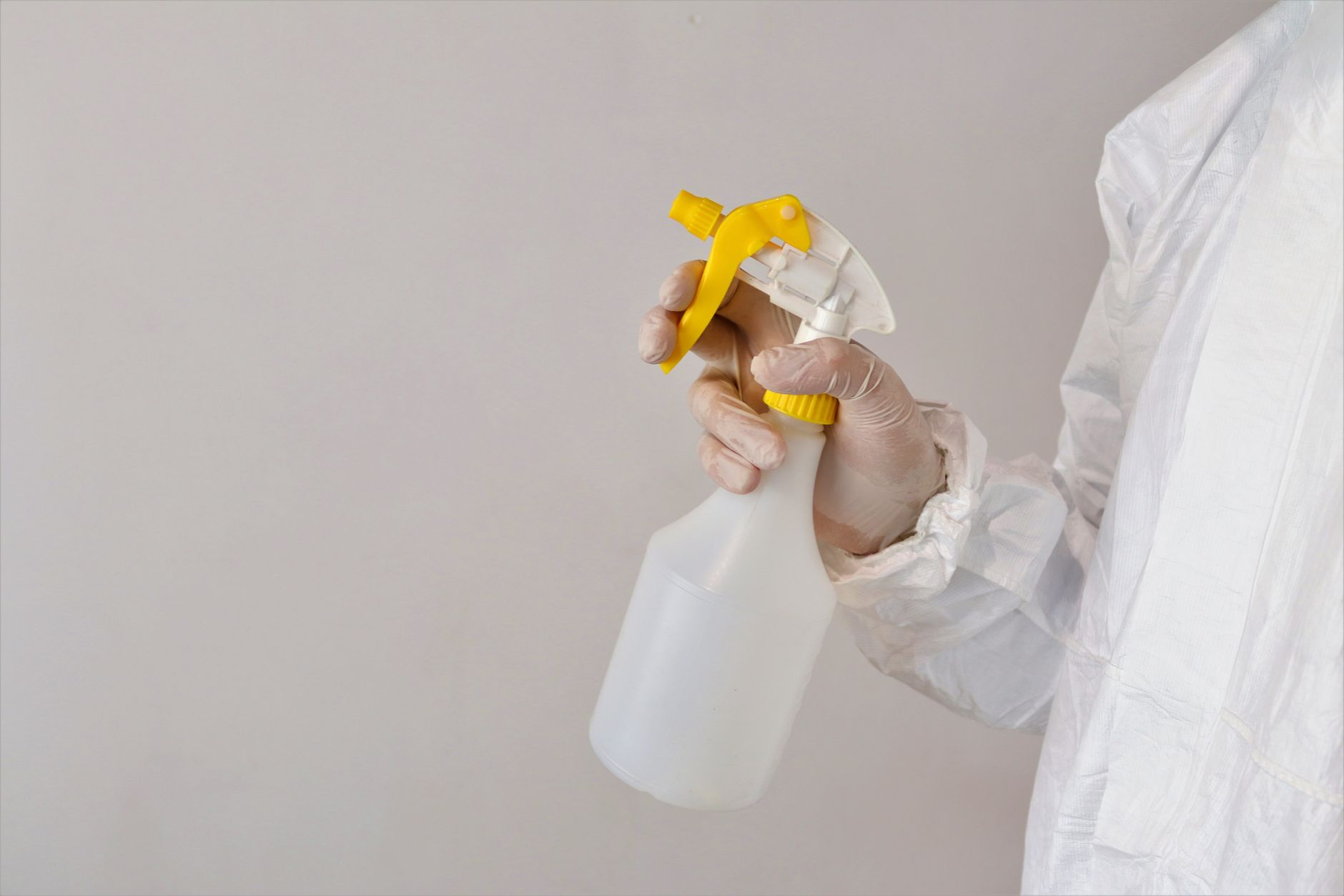 person spraying isopropyl alcohol on a mushroom grow shelf